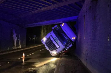 A lorry stuck under the railway bridge