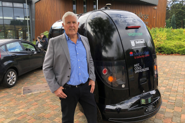 Councillor Ken Hawkins alongside a Connected Autonomous Vehicle (CAV) being used to transport goods as part of a trial in Solihull.