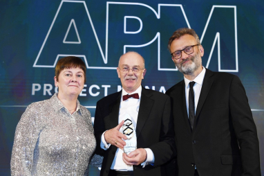 Nick Smallwood, centre, being presented with his award by Sue Kershaw, president of APM and managing director, transportation at Costain, with host Hugh Dennis.