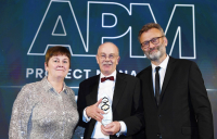 Nick Smallwood, centre, being presented with his award by Sue Kershaw, president of APM and managing director, transportation at Costain, with host Hugh Dennis.